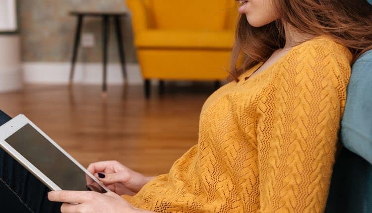 Smiling teenage girl sitting on the floor with tablet pc