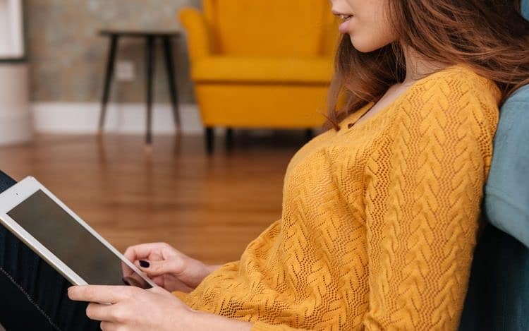 Smiling teenage girl sitting on the floor with tablet pc