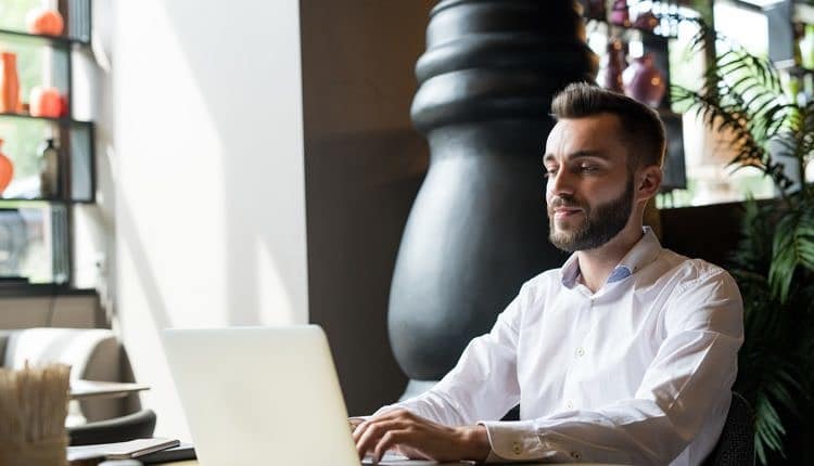 Successful Bearded Man Working in Cafe