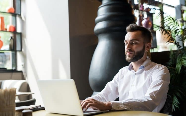 Successful Bearded Man Working in Cafe