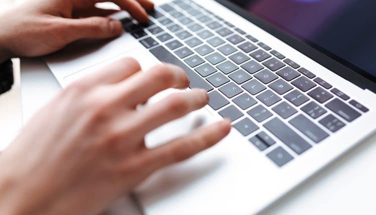 Photo of man hands typing on laptop