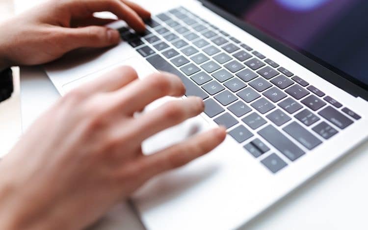 Photo of man hands typing on laptop