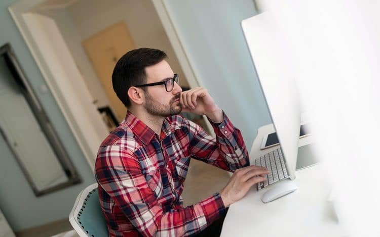 Young handsome designer working on project on computer