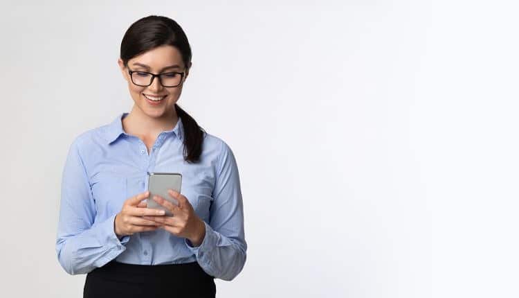 Business Girl Browsing On Smartphone Standing Over White Background