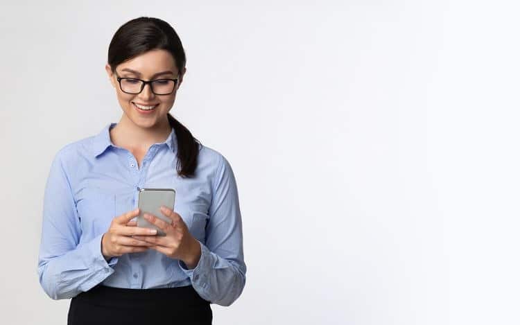 Business Girl Browsing On Smartphone Standing Over White Background