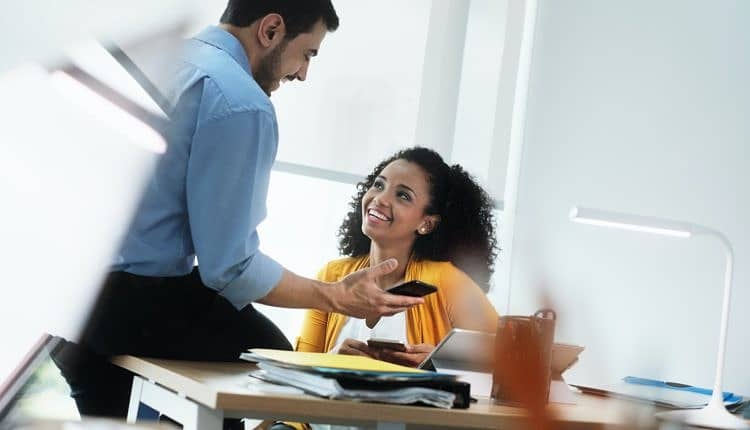 Business People Laughing In Office Watching Video Pictures On Smartphone