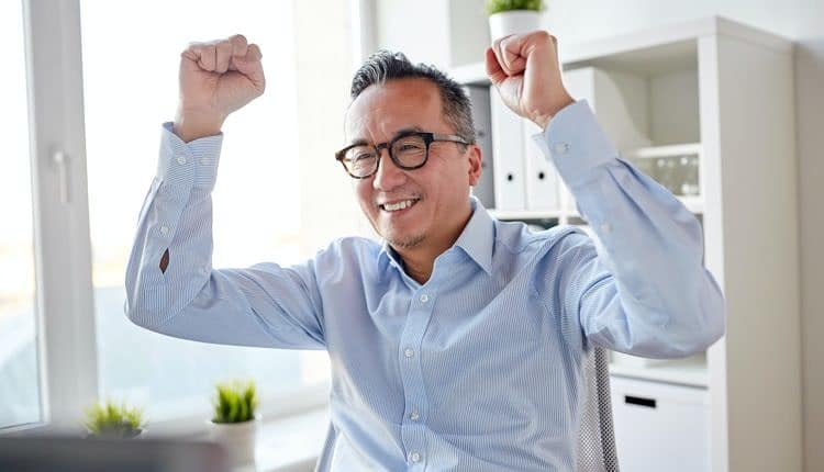 happy businessman celebrating victory at office