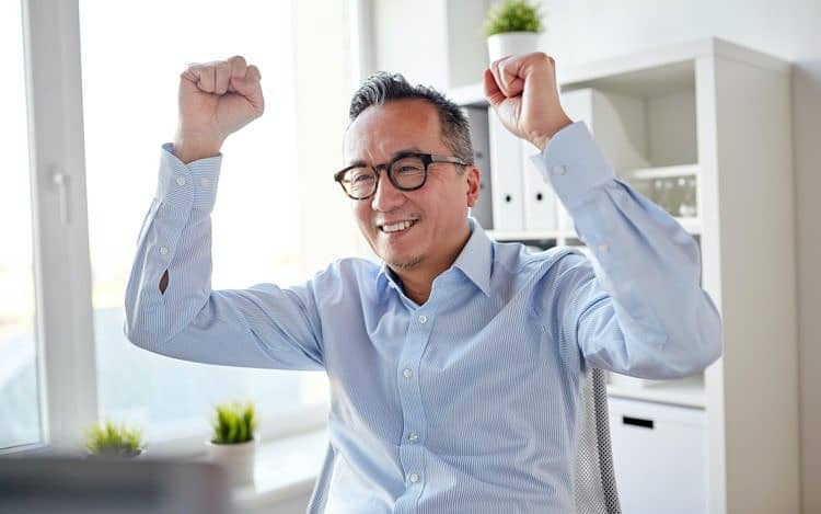 happy businessman celebrating victory at office