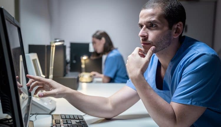 Health Care Workers In Hospital With Computer And Equipment