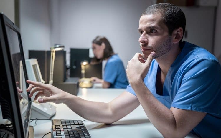 Health Care Workers In Hospital With Computer And Equipment