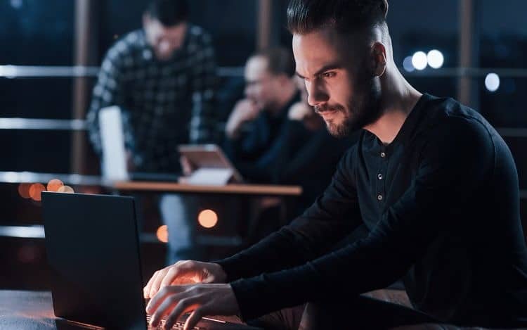 Team of young business people works on their project at night time in the office