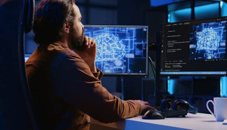 Freelancing programmer writes artificial intelligence code on desktop PC