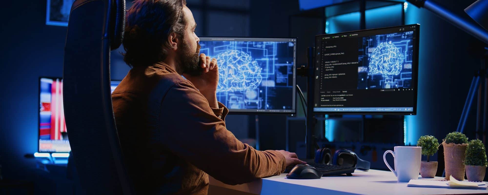 Freelancing programmer writes artificial intelligence code on desktop PC