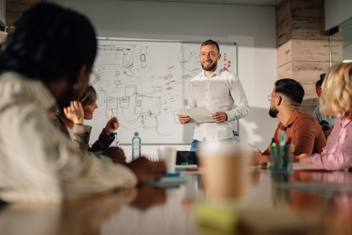 Marketing team listening to project manager giving presentation in meeting room