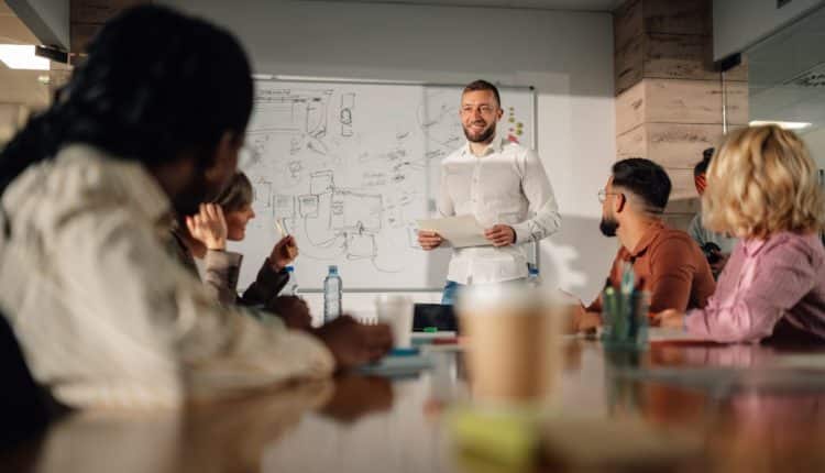 Marketing team listening to project manager giving presentation in meeting room