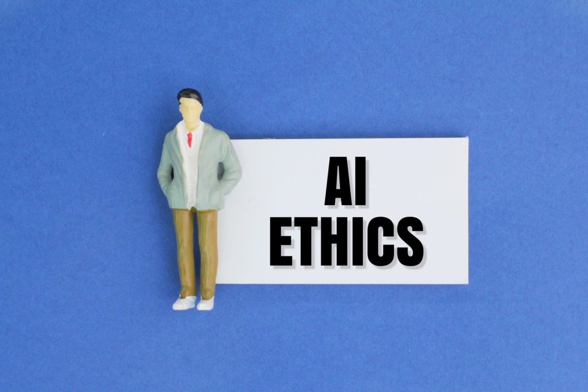 miniature people and paper with the word AI ETHICS. Ethical concepts for artificial intelligence