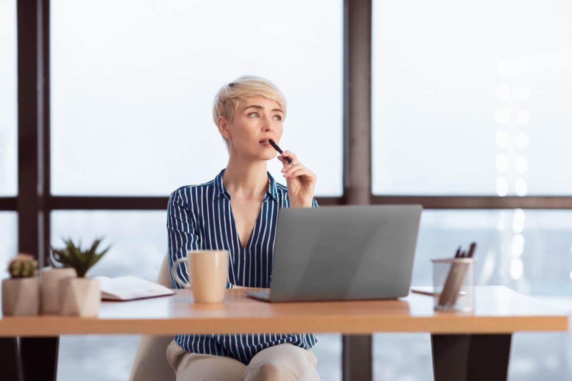 Pensive Businesswoman At Laptop Thinking On A Task In Office