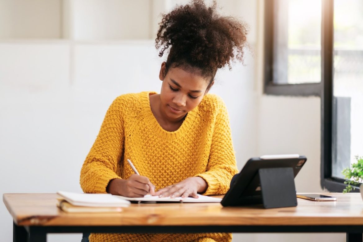 African american student woman in sweater watching e-learning to