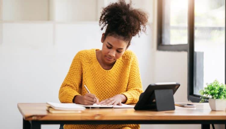 African american student woman in sweater watching e-learning to