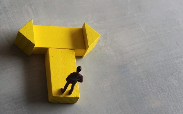 Das Astronomische Gedankenexperiment 10 Miniature man standing at a turning point. Copy space for text.