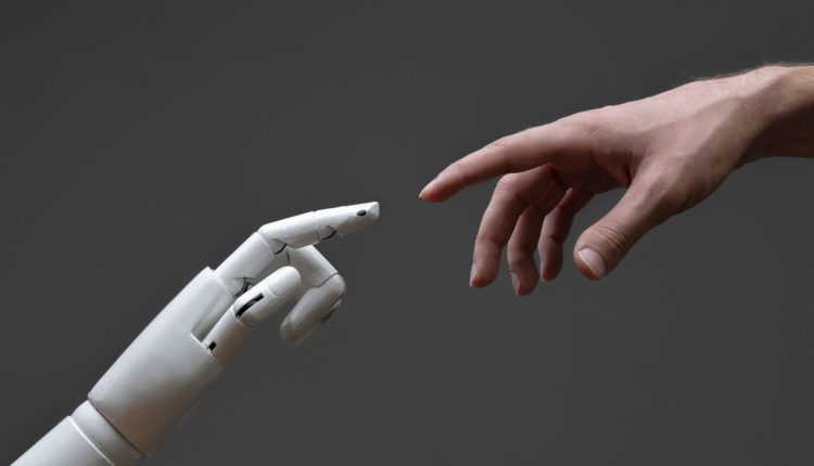 KI-gestütztes Upskilling: Ein Leitfaden für Führungskräfte 2 a robotic arm touching human hand, man and machine friendship