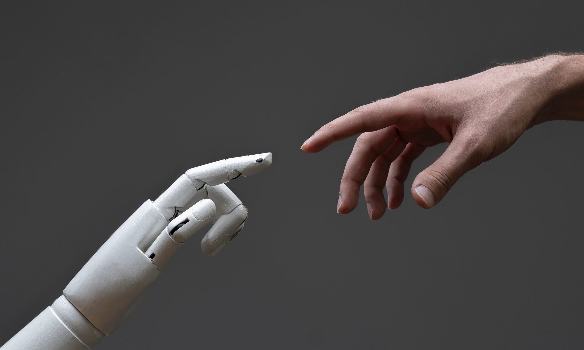 KI-gestütztes Upskilling: Ein Leitfaden für Führungskräfte 4 a robotic arm touching human hand, man and machine friendship