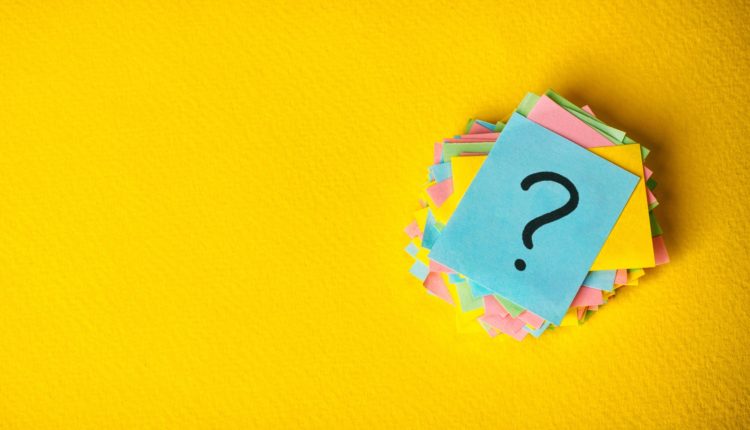 question marks written reminders tickets on yellow vintage paper background