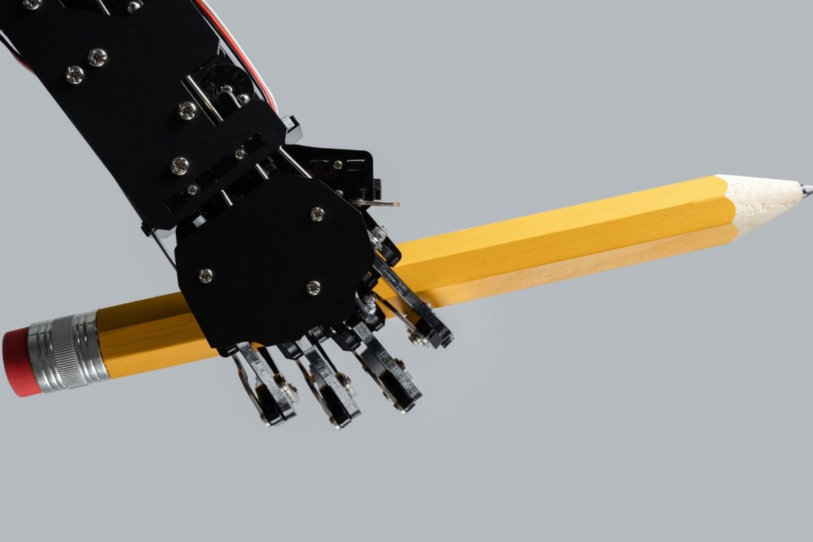 Was eine agentische KI für L&D leisten kann 2 Real robotic hand with big pencil. Concept of AI-powered chatbot development